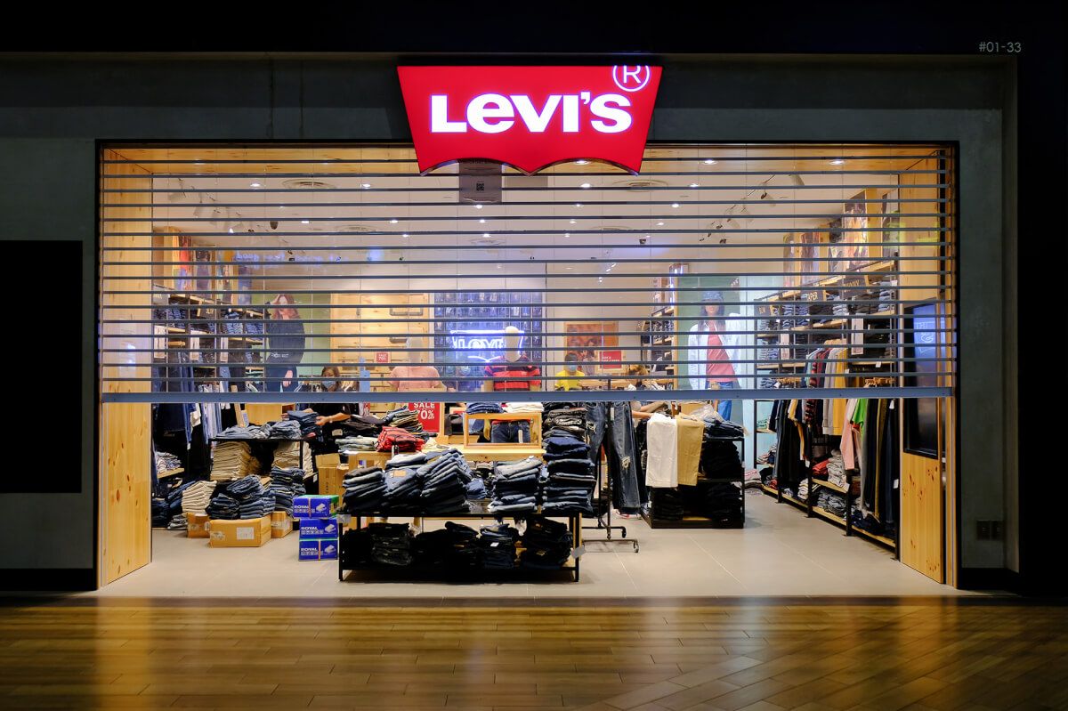 Open-grille security shutter part-closed over a Levi’s store, keeping the display visible