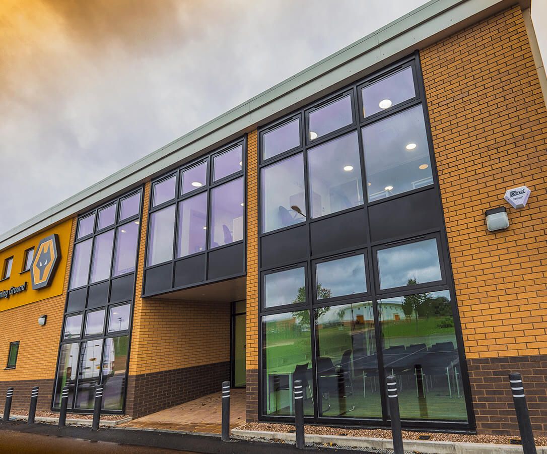Dark aluminium curtain walling and glazing at the Wolves training-ground building